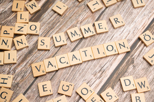 scrabble tiles spelling vacation on a wooden surface