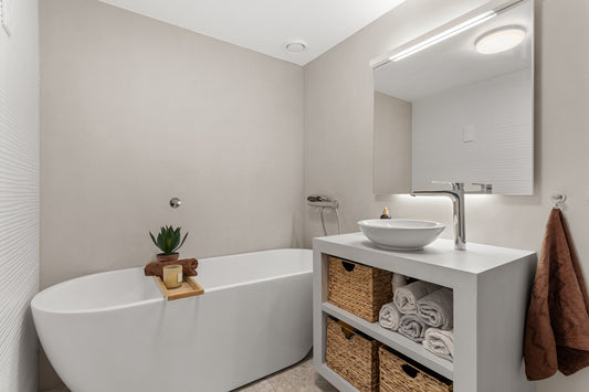 A bathroom with a tub, sink and mirror