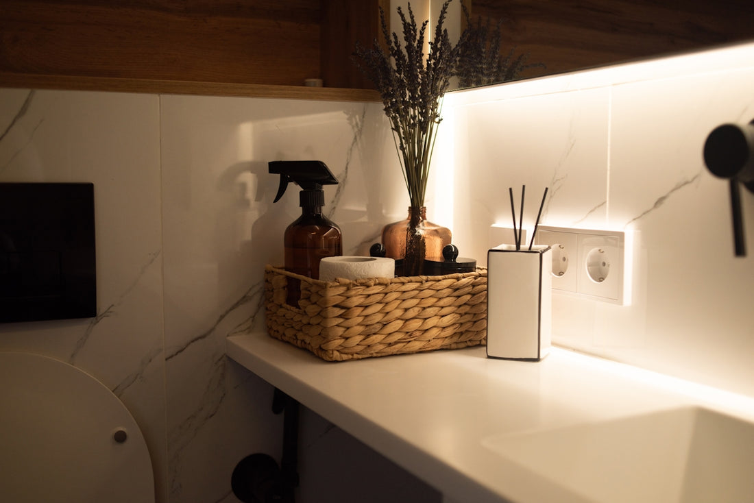 A bathroom with a sink, toilet and a basket on the counter