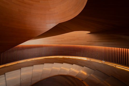 Curving wooden staircase with warm ambient lighting