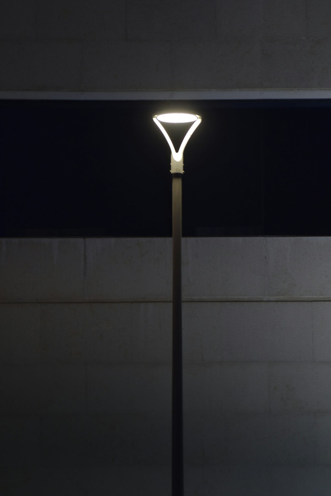 Modern street lamp illuminated at night.