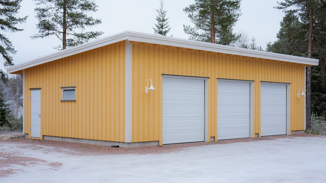 A bright yellow garage with three doors in snow