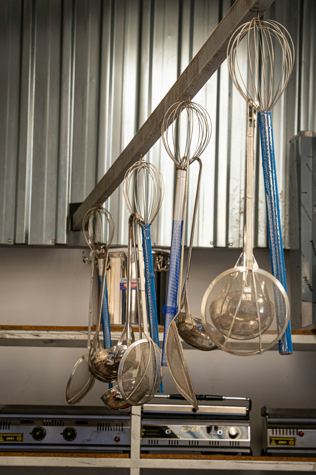 Various kitchen utensils hanging on a rack.