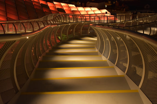 Modern illuminated walkway with curved metal railings