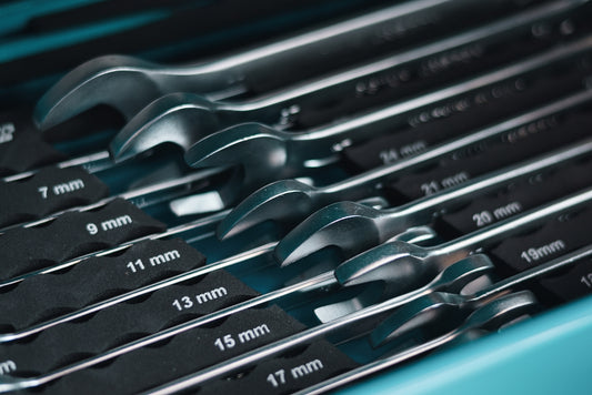 A set of metal wrenches in a toolbox