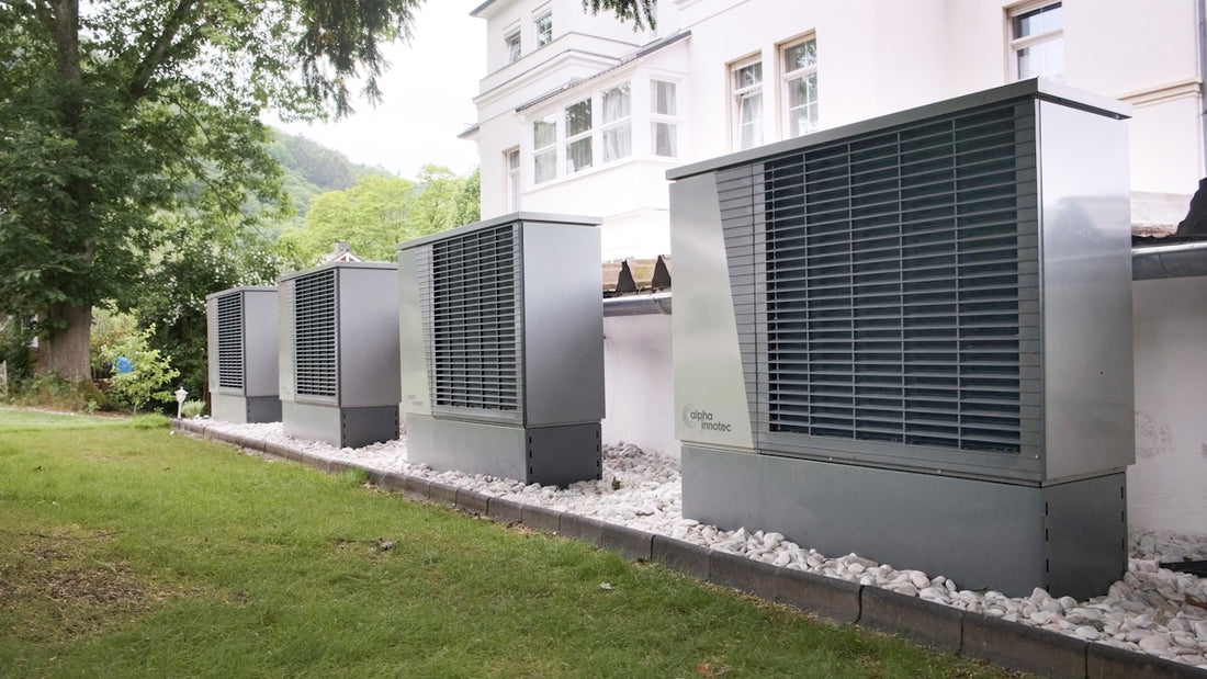 Four industrial air conditioning units lined up outside building
