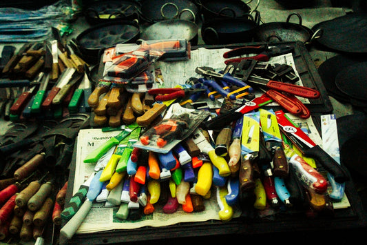 Assortment of colorful knives and tools displayed on a table.
