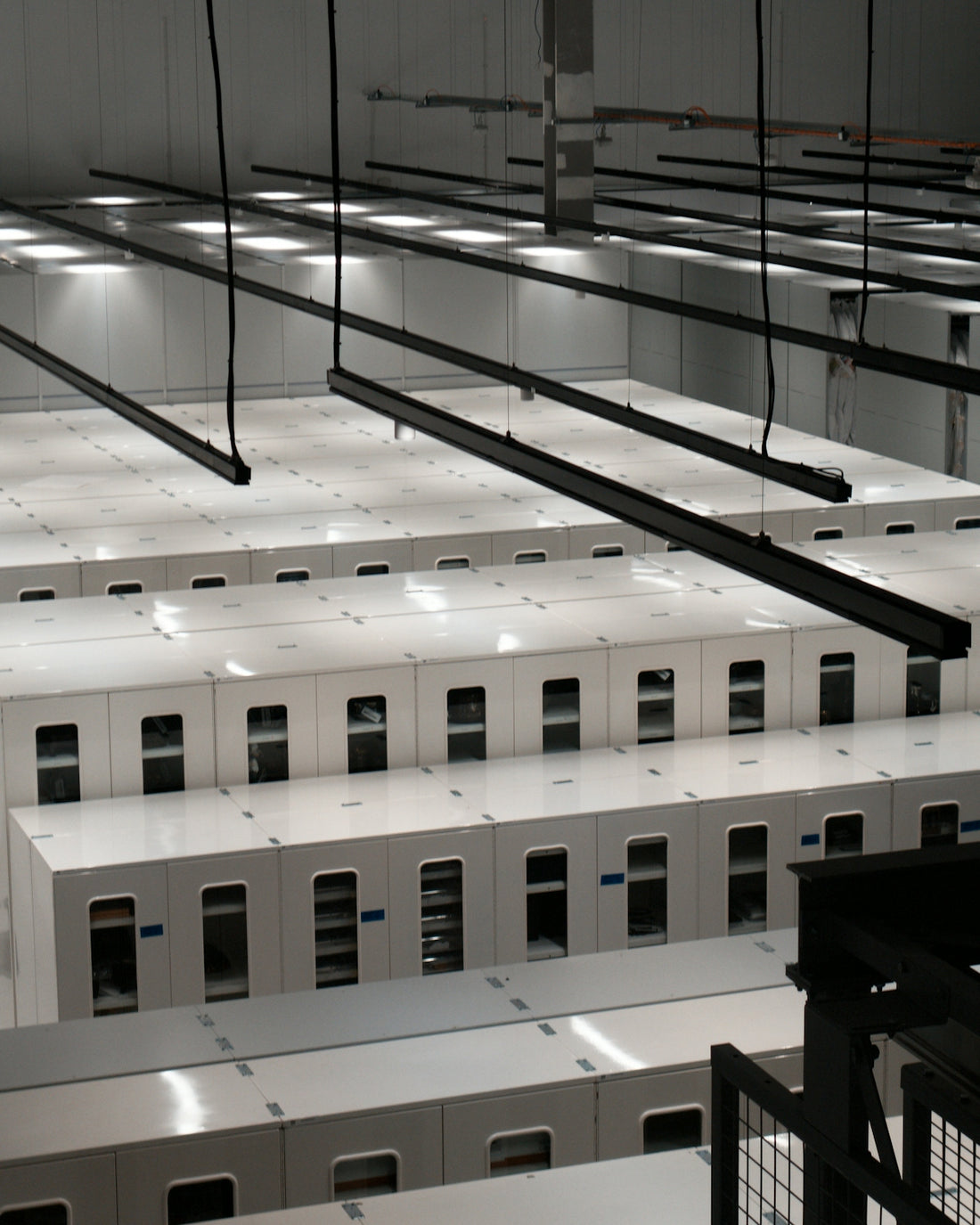 Modern data center with rows of white server cabinets.
