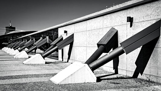 Black and white view of angled steel supports against a concrete building wall